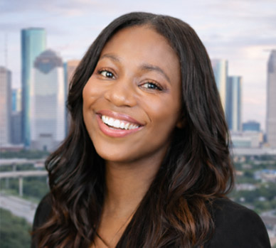 Attorney Joy Wells: Professional headshot with a city skyline background.